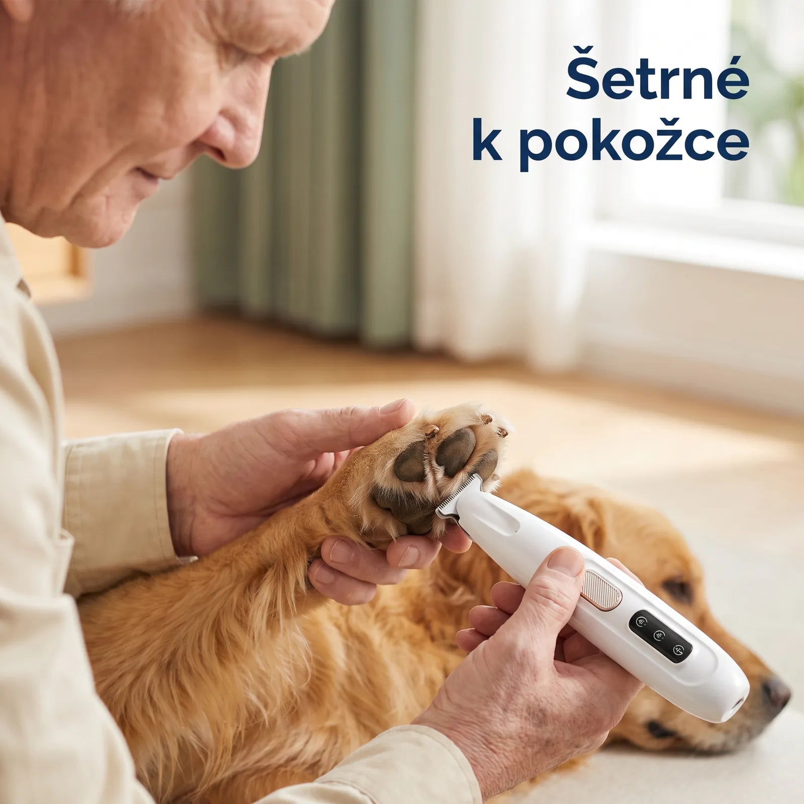 Muž v klidu zastřihuje srst mezi polštářky tlapky svého zlatého retrívra malým bílým zastřihovačem Kalivoro PawTrim Pro — jemné k pokožce